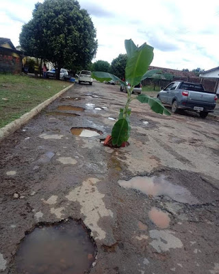 Divinópolis de Goiás: cidadã, em  protesto, bate boca com prefeito ao plantar bananeira em rua com paisagem lunar